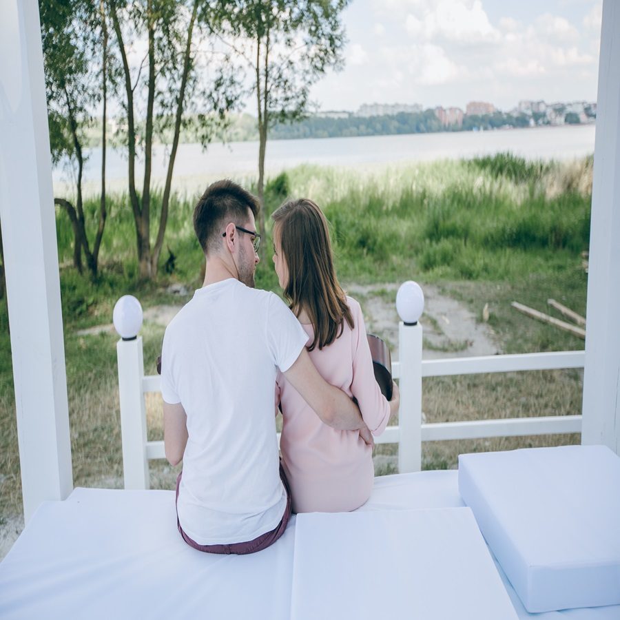 couple-backs-sitting-bed-looking-into-their-eyes